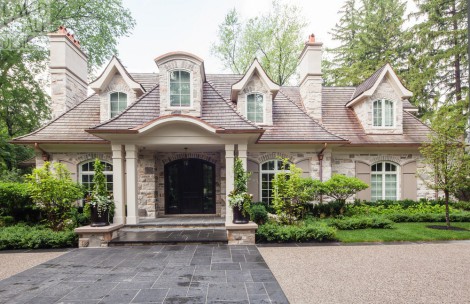 Dormers, stone accents above windows with shutters, chimney with copper accents