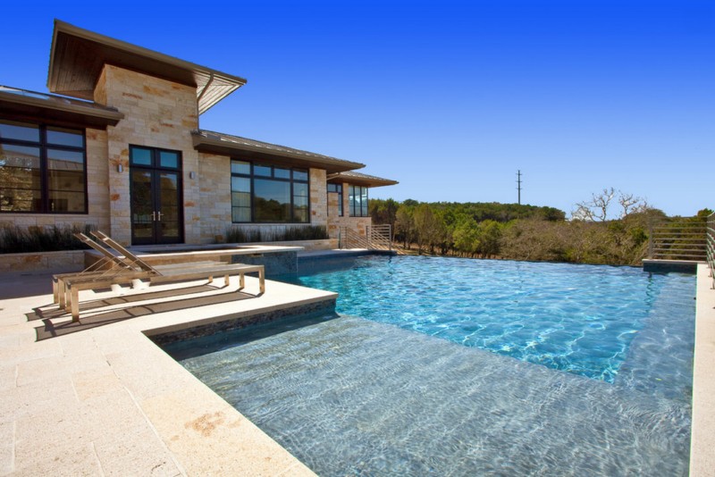 texas stone exterior with poolside chairs