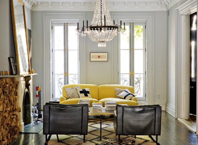 light living room with chandelier and accent woodworking, including yellow couch